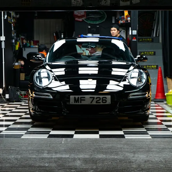 Acabado de la pintura de un Porsche negro en un taller; fotografía de referencia.