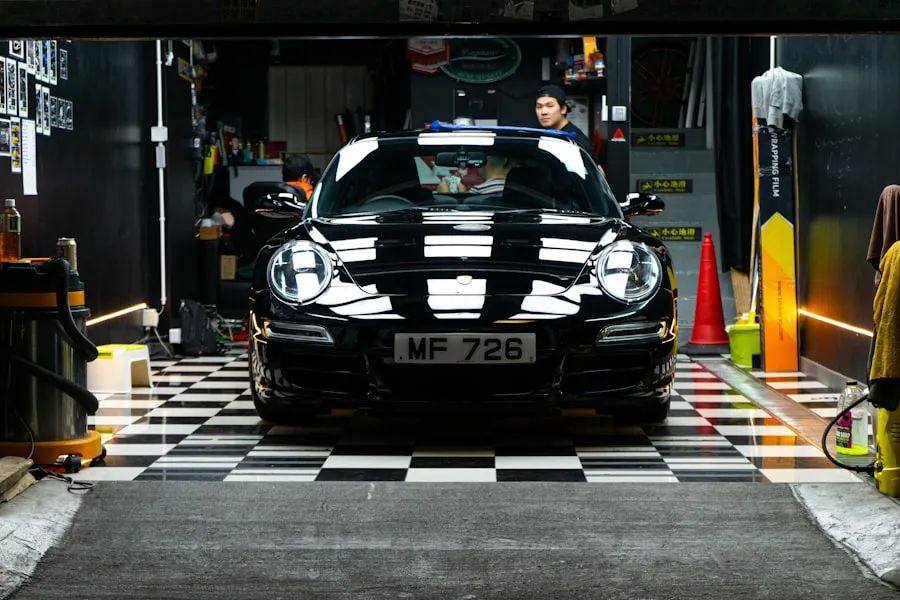 Fotografía de referencia: faros y frente de un Porsche negro en un taller.